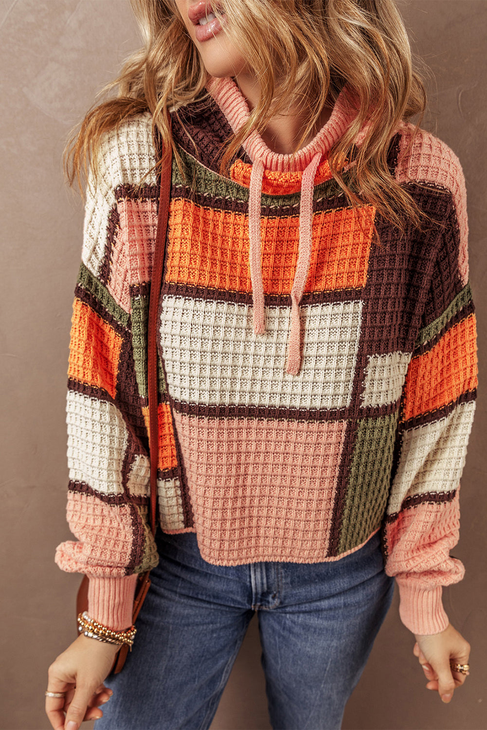 Orangefarbener block-waffelstrickpullover mit kordelzug und rundhalsausschnitt