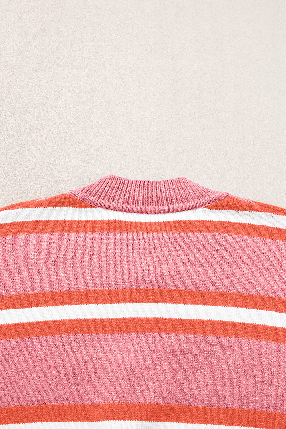 Rosa gestreifter strickpullover mit schulterknöpfen