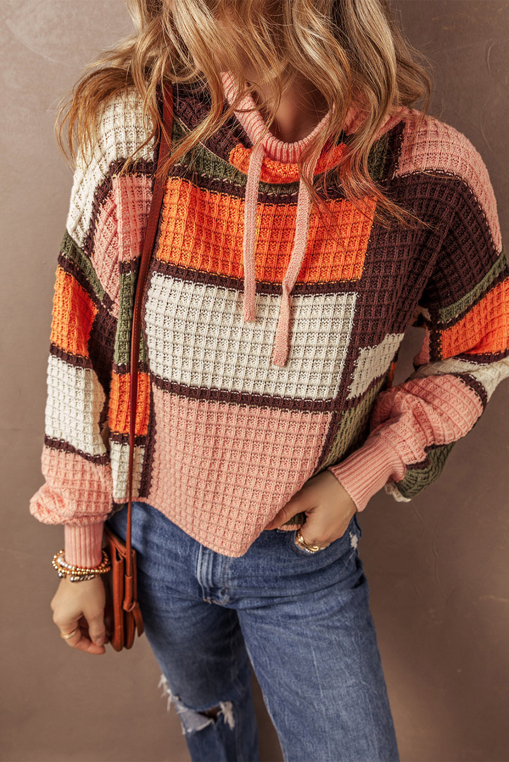 Orangefarbener block-waffelstrickpullover mit kordelzug und rundhalsausschnitt