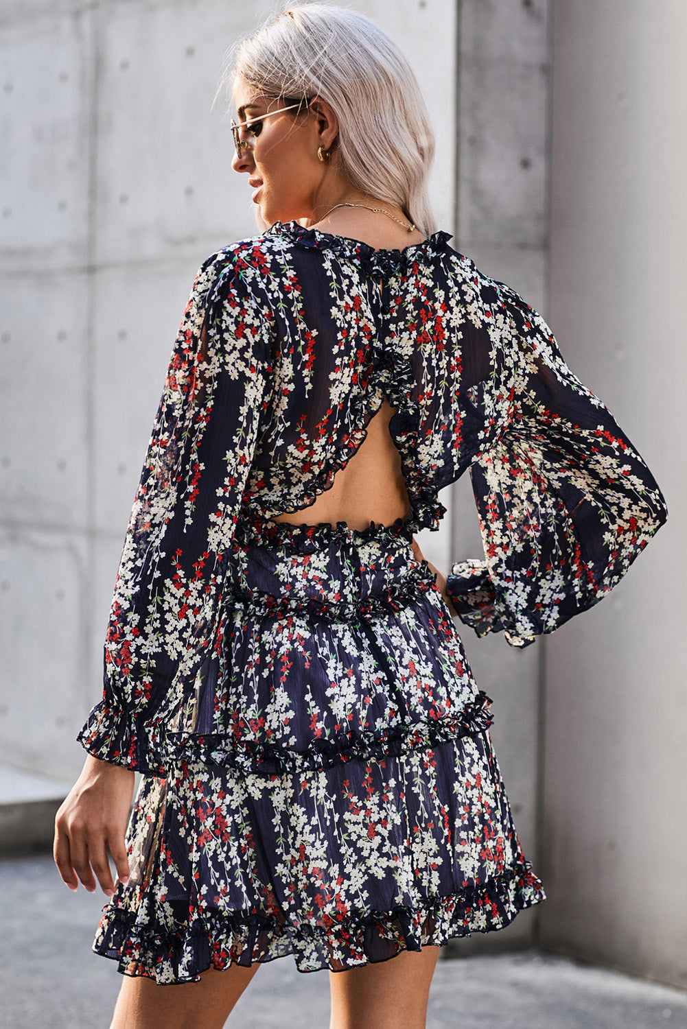 Blaues kleid mit rüschenbesatz und offenem rücken mit blumenmuster