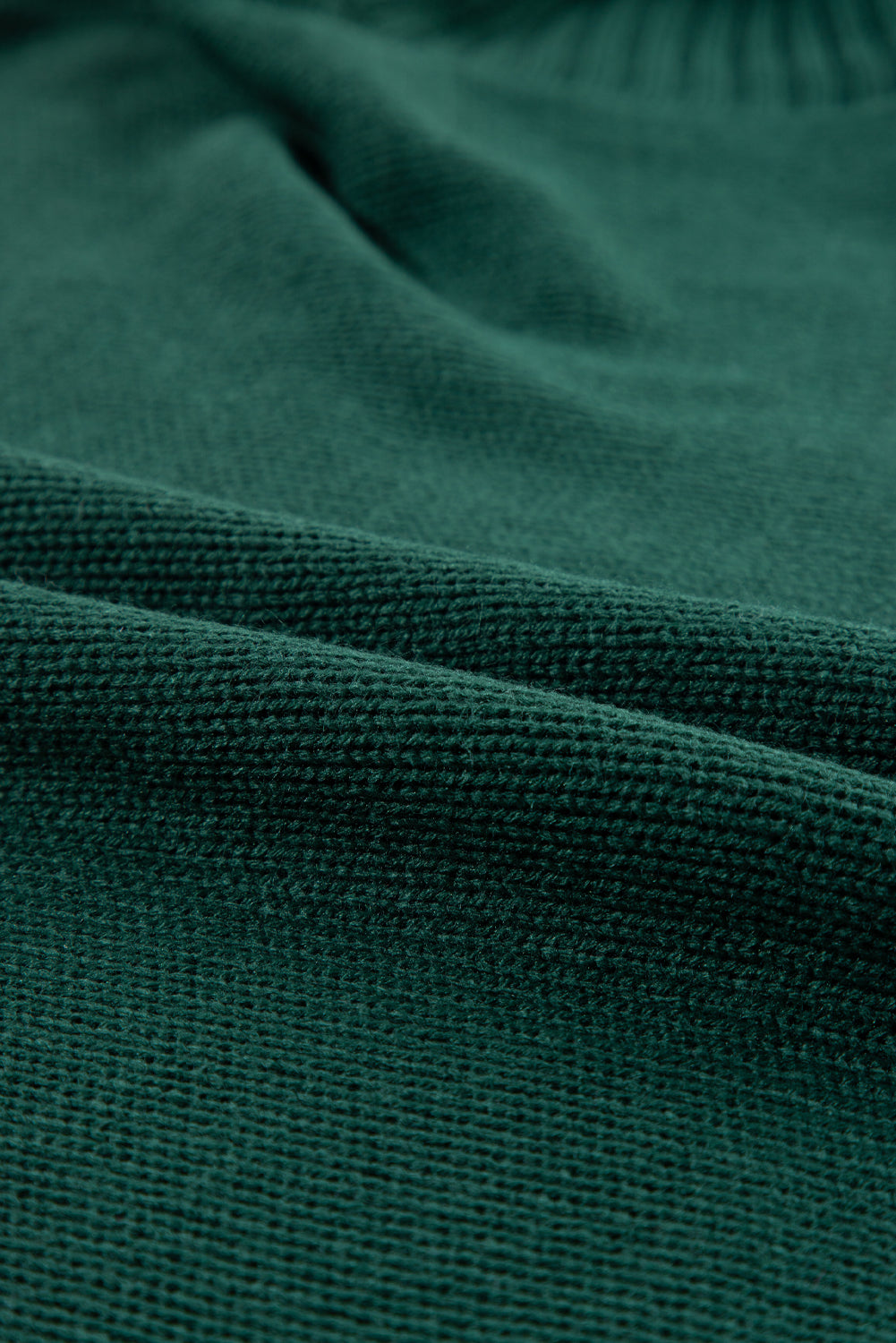 Schwarz-grüner pullover mit gesticktem buchstaben und hohem ausschnitt