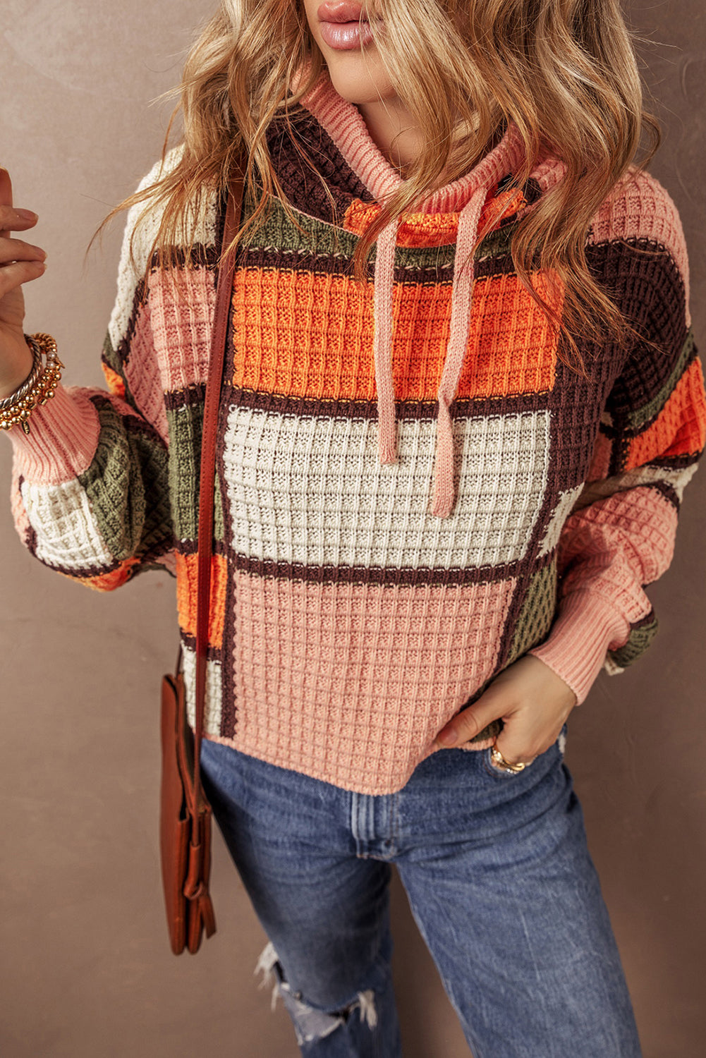 Orangefarbener block-waffelstrickpullover mit kordelzug und rundhalsausschnitt
