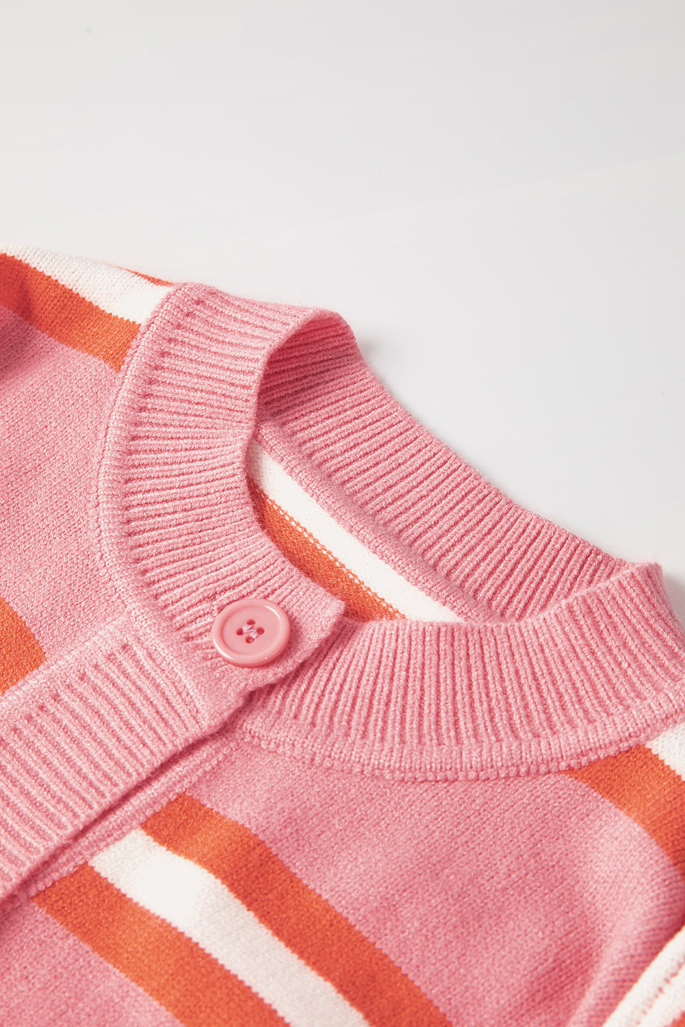 Rosa gestreifter strickpullover mit schulterknöpfen