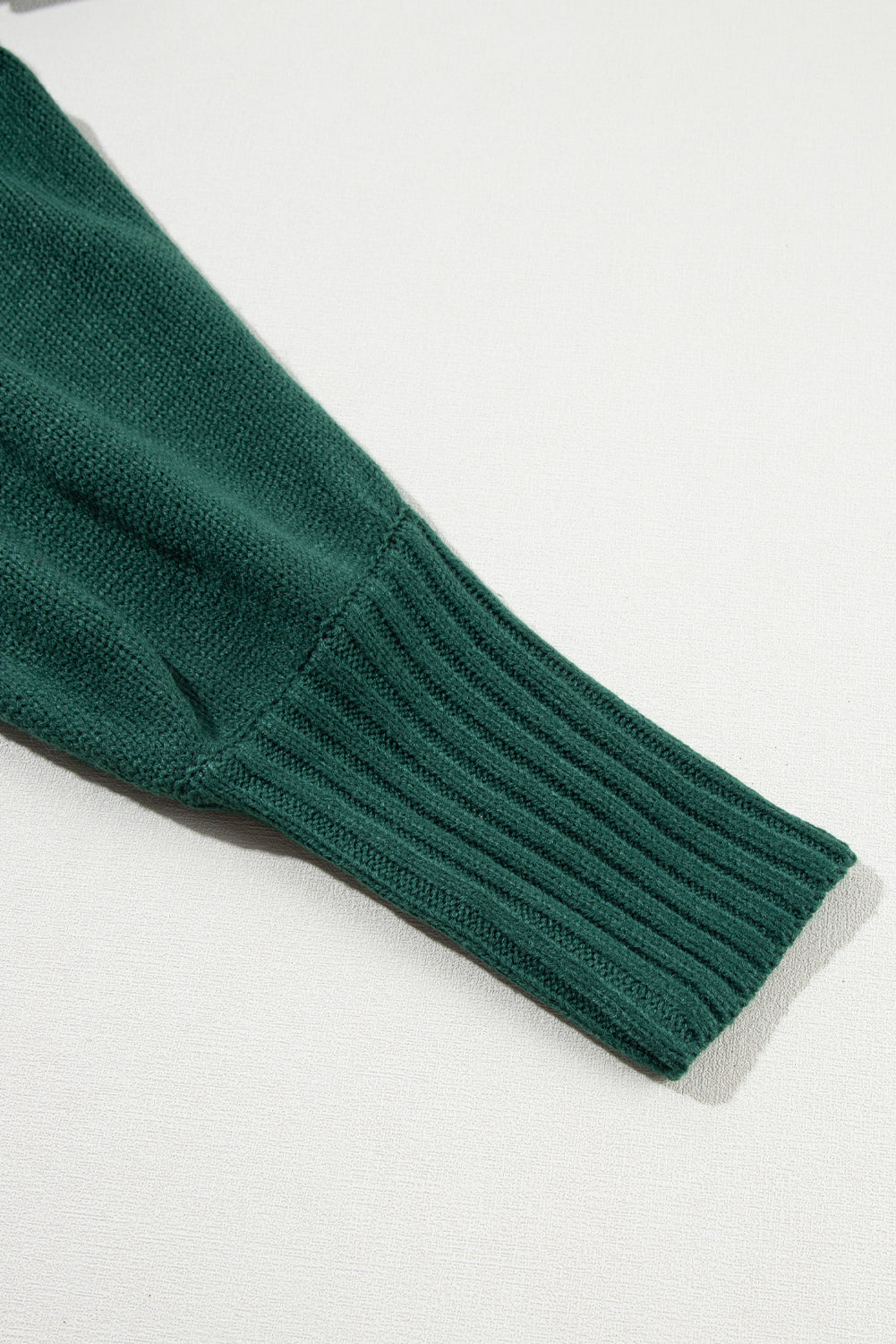 Schwarz-grüner pullover mit gesticktem buchstaben und hohem ausschnitt