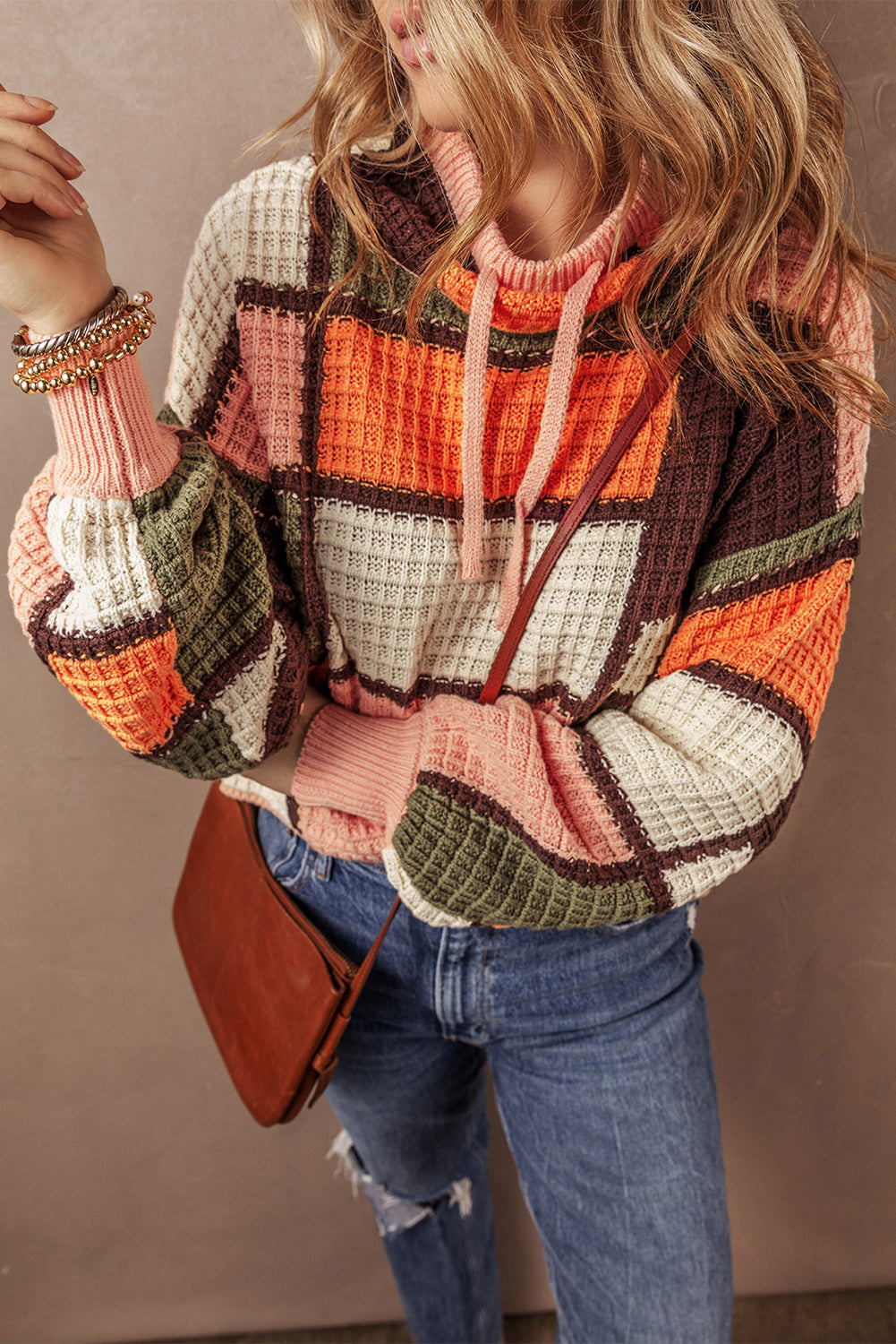 Orangefarbener block-waffelstrickpullover mit kordelzug und rundhalsausschnitt