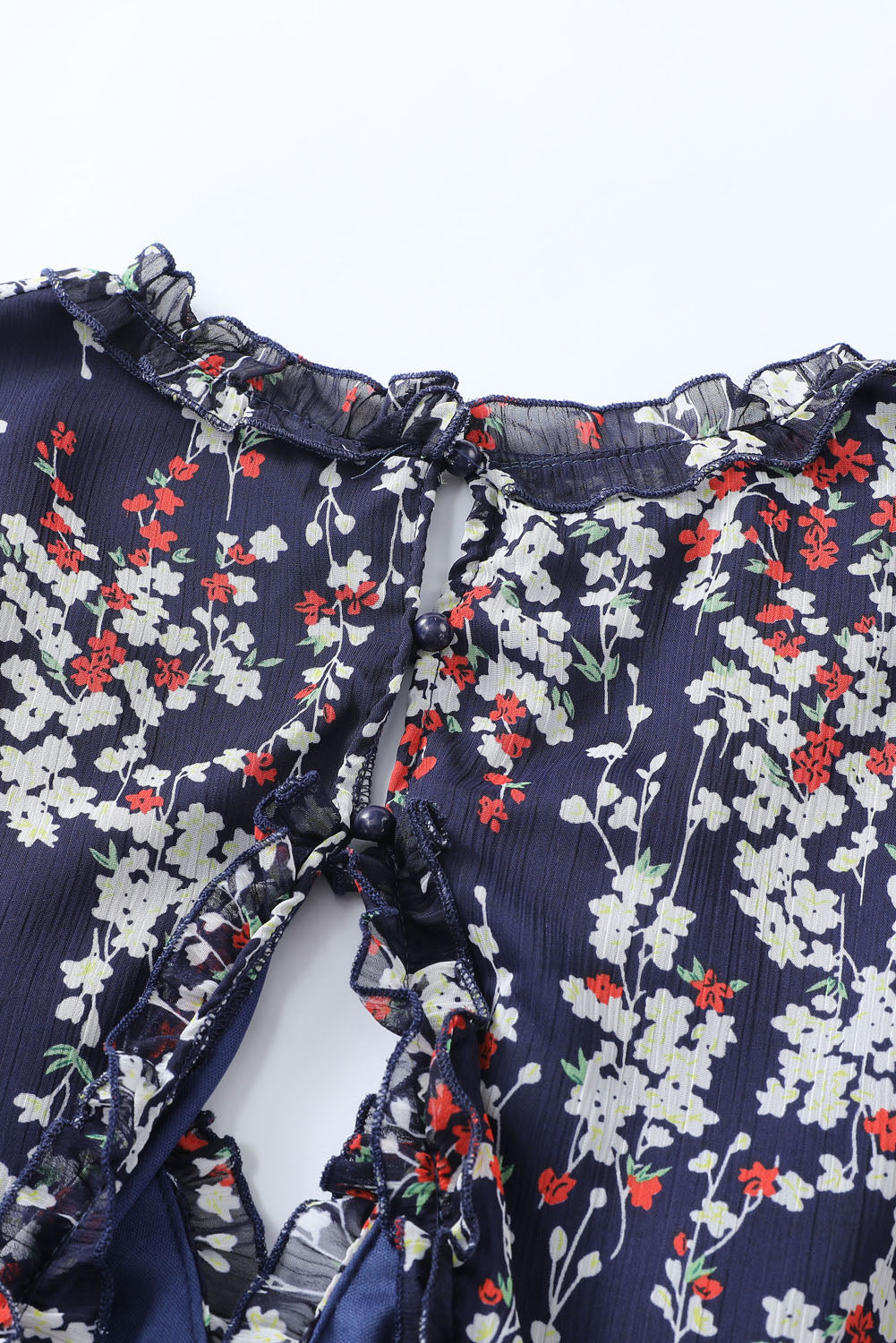 Blaues kleid mit rüschenbesatz und offenem rücken mit blumenmuster