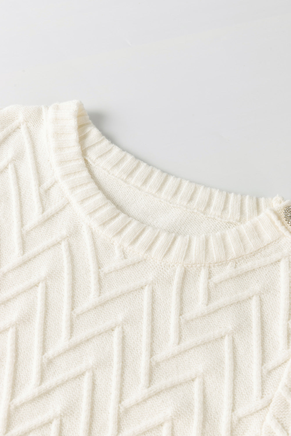Weißer strukturierter strickpullover mit knopfdekor