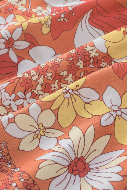 Orangefarbenes kleid mit weiten flatterärmeln und blumenmuster