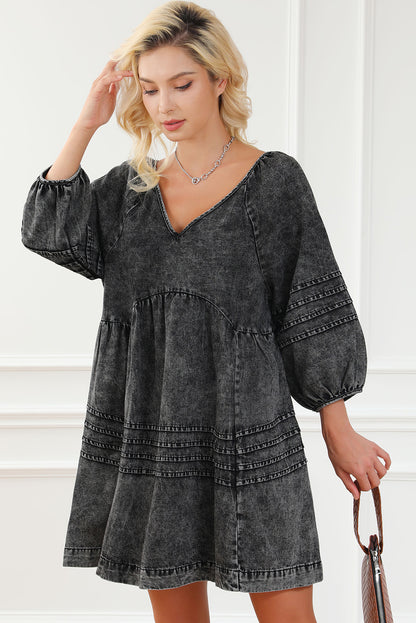 Schwarzes babydoll-kleid mit plissiertem v-ausschnitt und puffärmeln aus denim