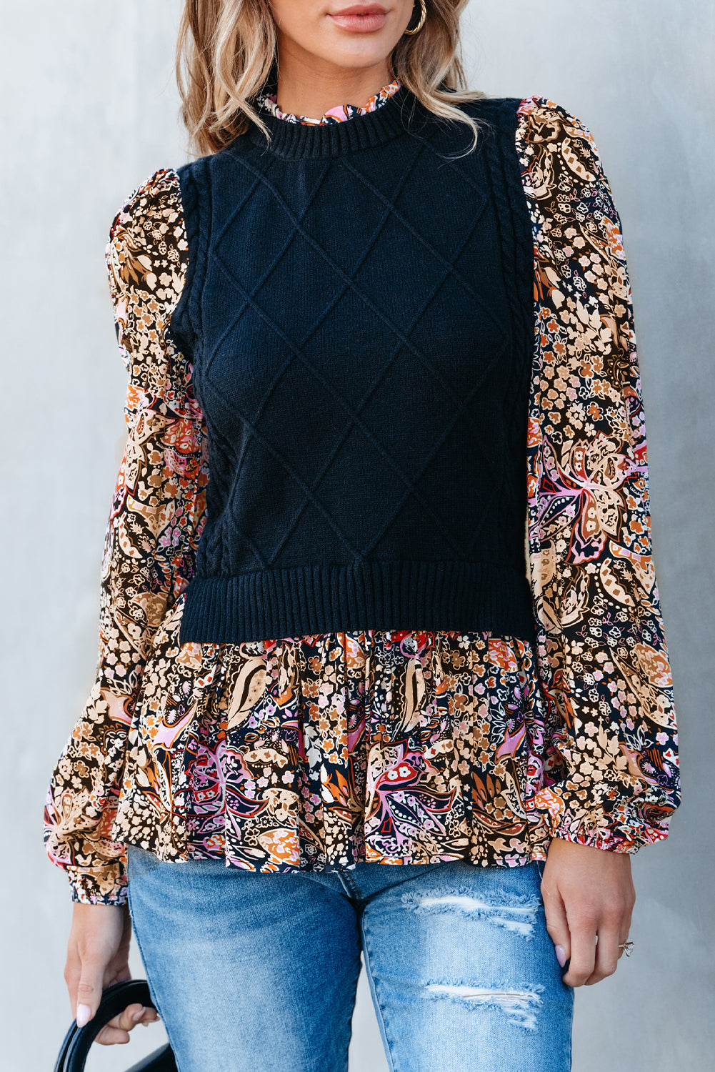 Schwarzer schößchenpullover mit kontrastierenden blumenärmeln