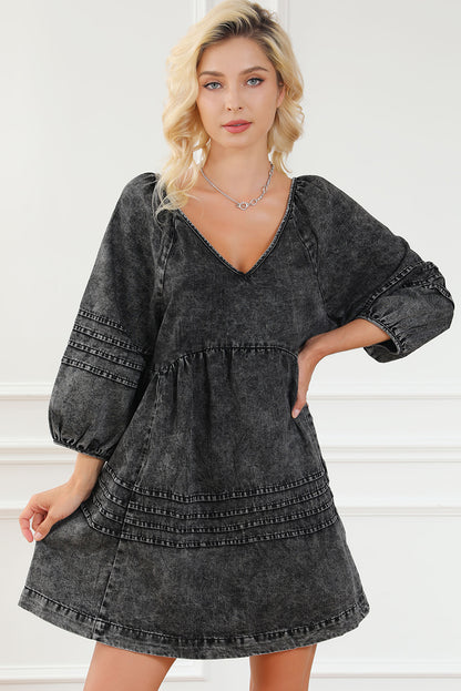 Schwarzes babydoll-kleid mit plissiertem v-ausschnitt und puffärmeln aus denim