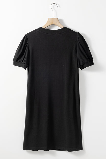 Schwarzes t-shirt-kleid mit plissiertem ausschnitt und puffärmel