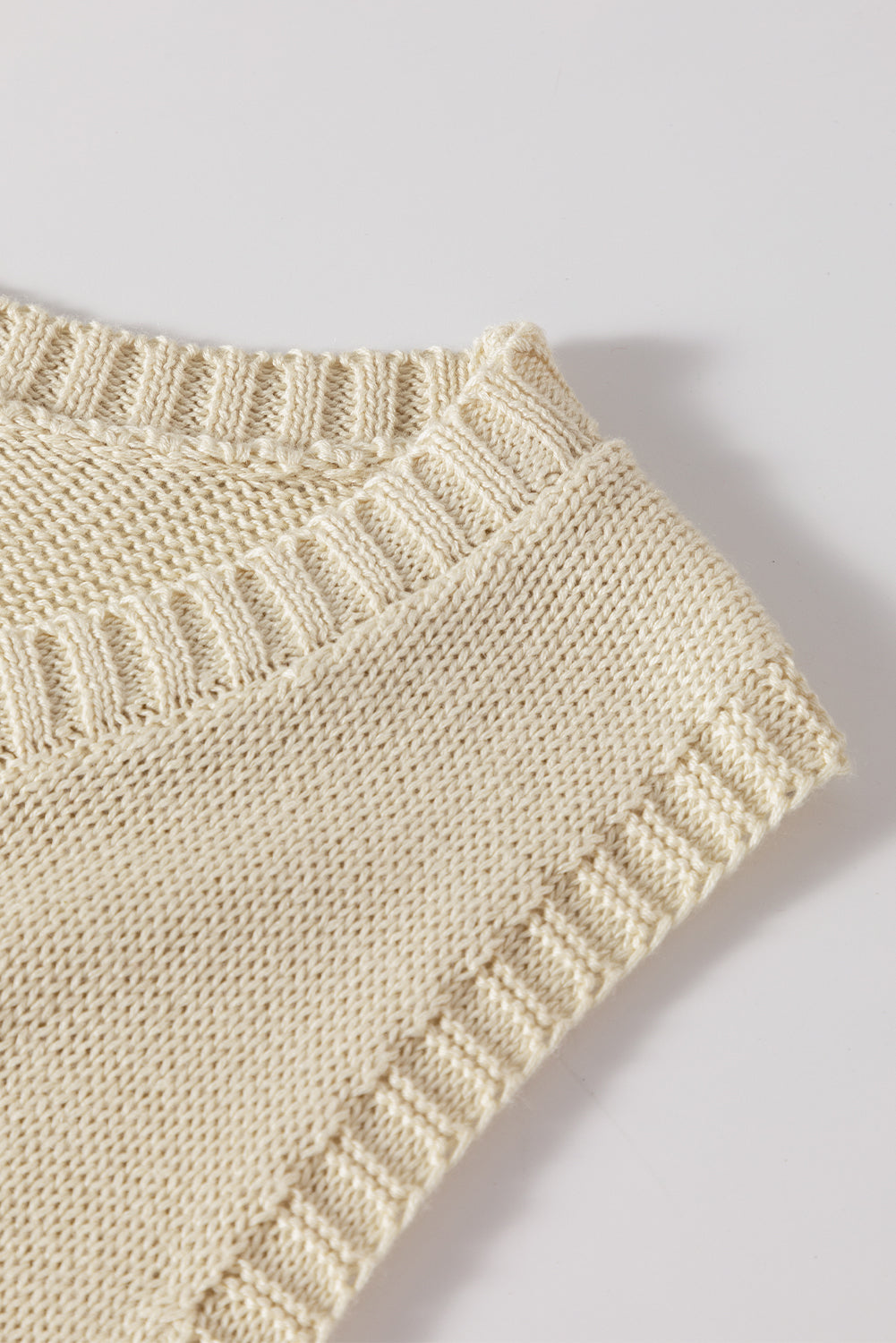 Beigefarbener pointelle-detail-pullover mit strickweste