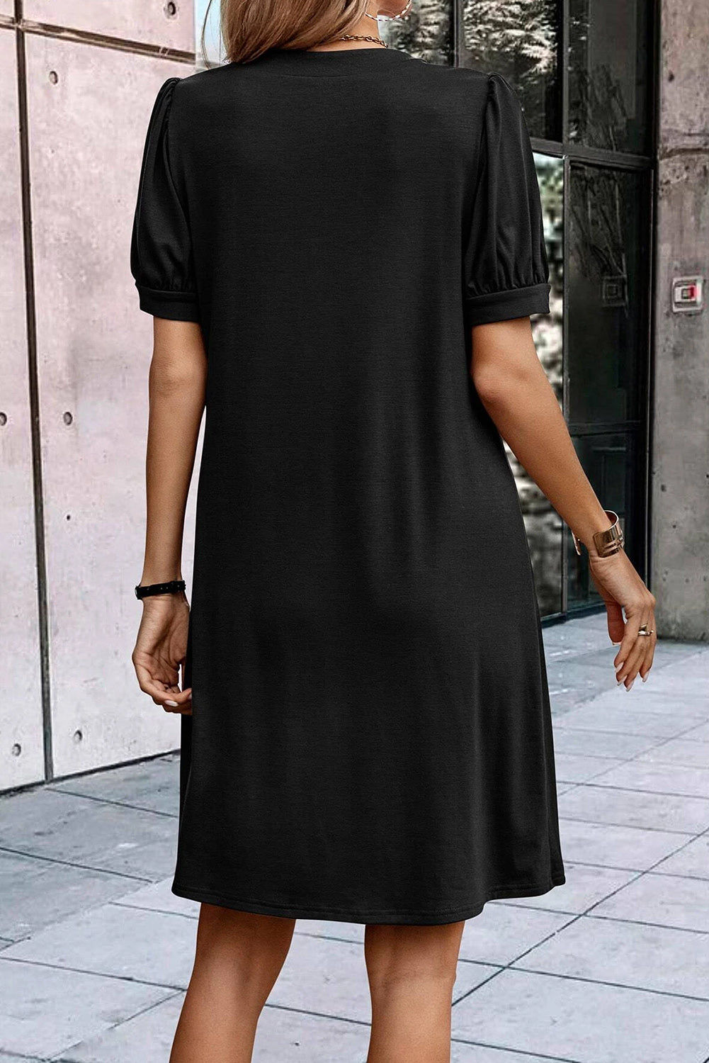 Schwarzes t-shirt-kleid mit plissiertem ausschnitt und puffärmel