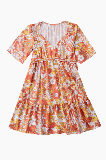 Orangefarbenes kleid mit weiten flatterärmeln und blumenmuster