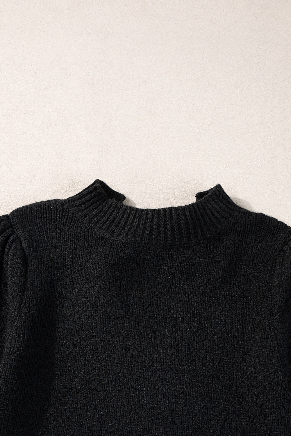 Schwarzer kurzarm-strickpullover mit geknotetem schlüsselloch im nacken