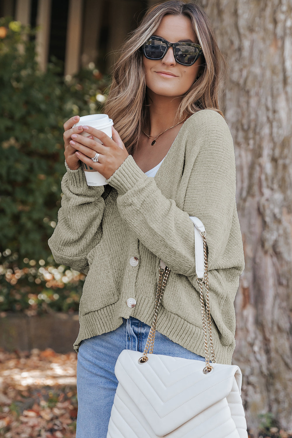 Grauer pullover mit taschen und knöpfen vorne