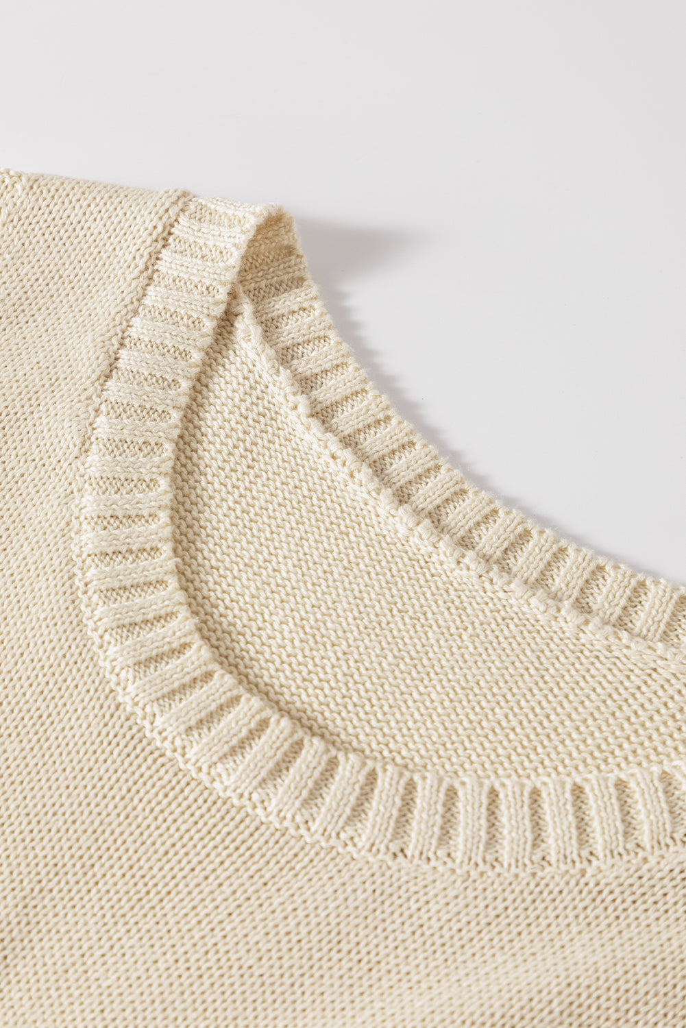 Beigefarbener pointelle-detail-pullover mit strickweste