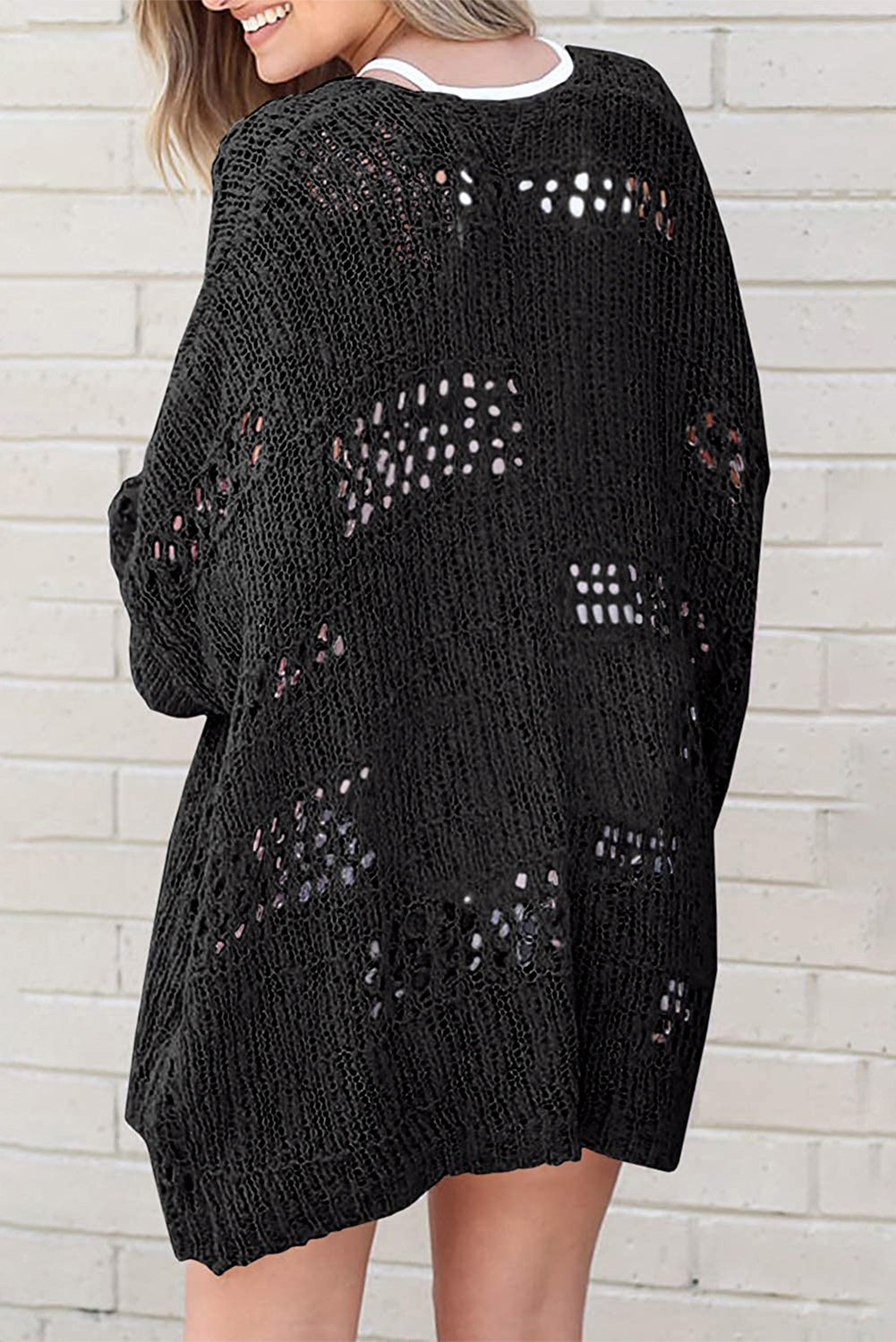 Schwarze lässige strickjacke mit dolman-ärmeln und lochmuster