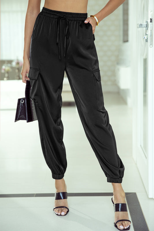 Schwarze satin-taschenhose mit kordelzug und elastischer taille