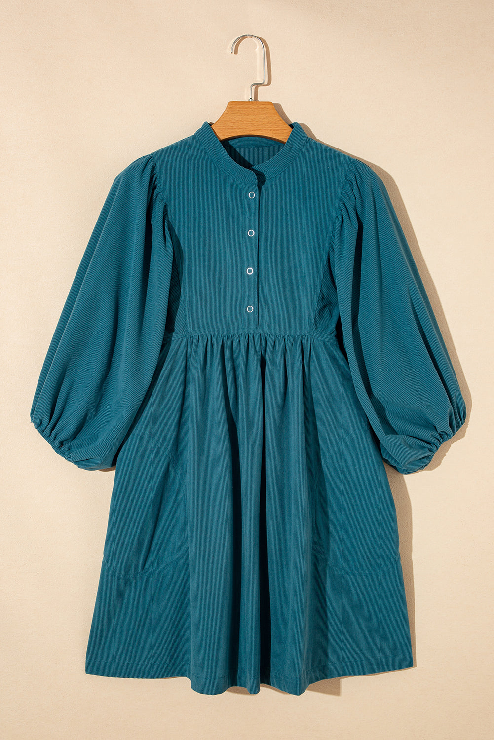 Blaues cord-knopf-kleid mit empire-taille und armband-ärmeln